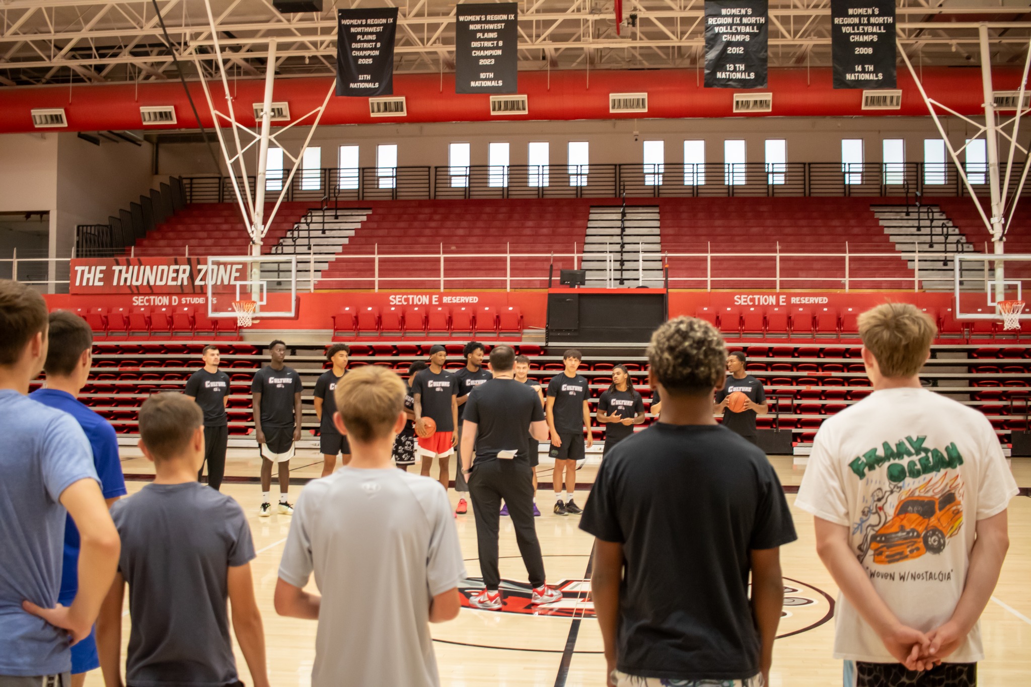 Players and coaches gather on a Wyoming basketball court